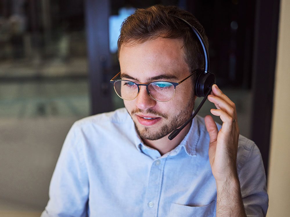 Call center, customer service and telemarketing with a man working in support with a headset in his office. Sales
